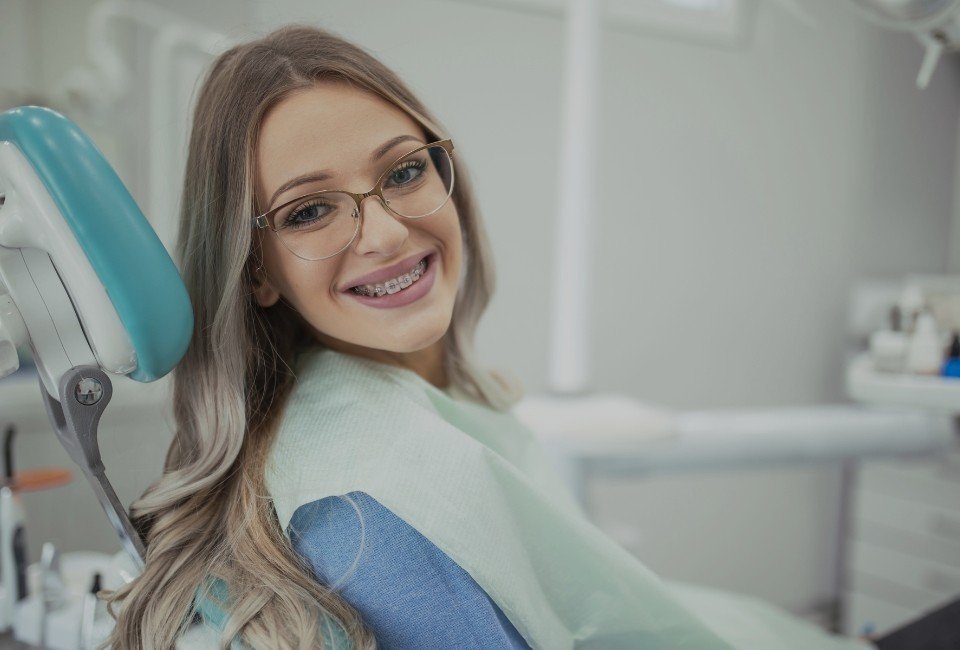 Kobieta w okularach na fotelu dentystycznym