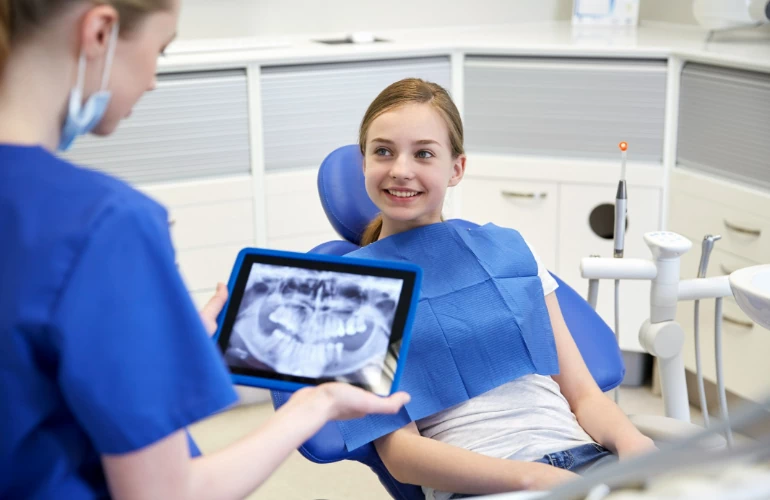 uśmiechnięta nastolatka na fotelu dentystycznym